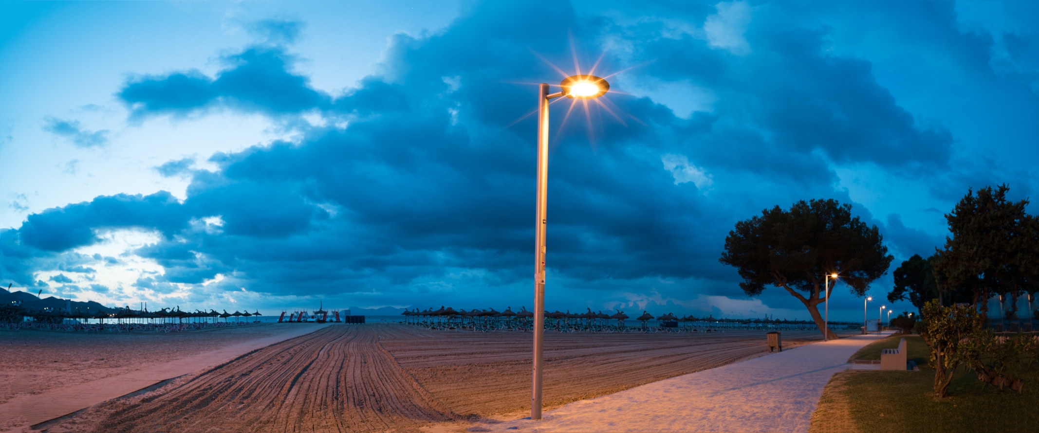 Smarte Straßenlaternen an einem Gehweg in der Nähe vom Strand.