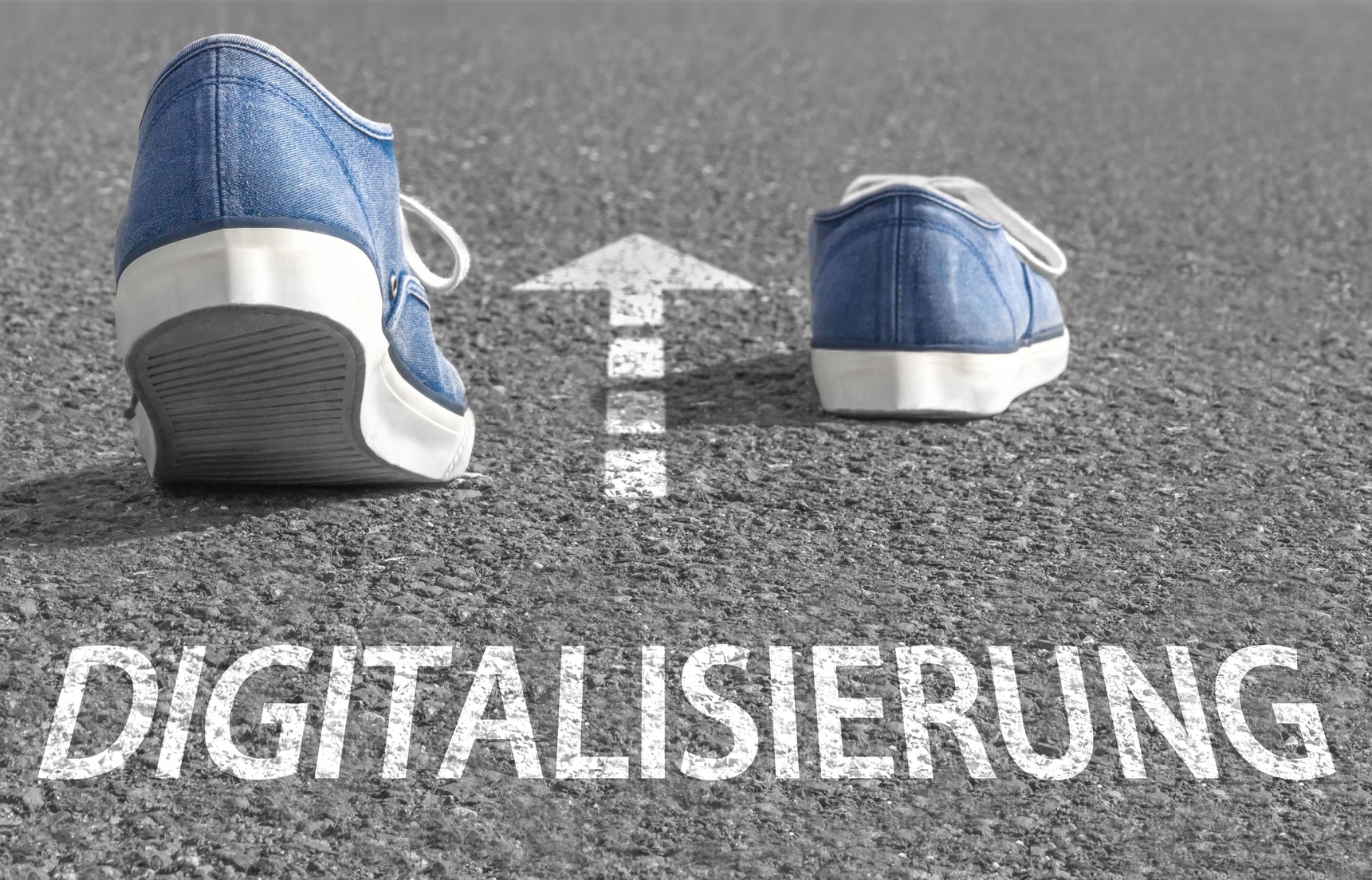 Auf Straße steht das Wort "Digitalisierung". Darüber ist ein weißer Pfeil gezeichnet. Zwei Schuhe gehen in die Richtung des Pfeils. Auf Straße steht das Wort "Digitalisierung". Darüber ist ein weißer Pfeil gezeichnet. Zwei Schuhe gehen in die Richtung des Pfeils.