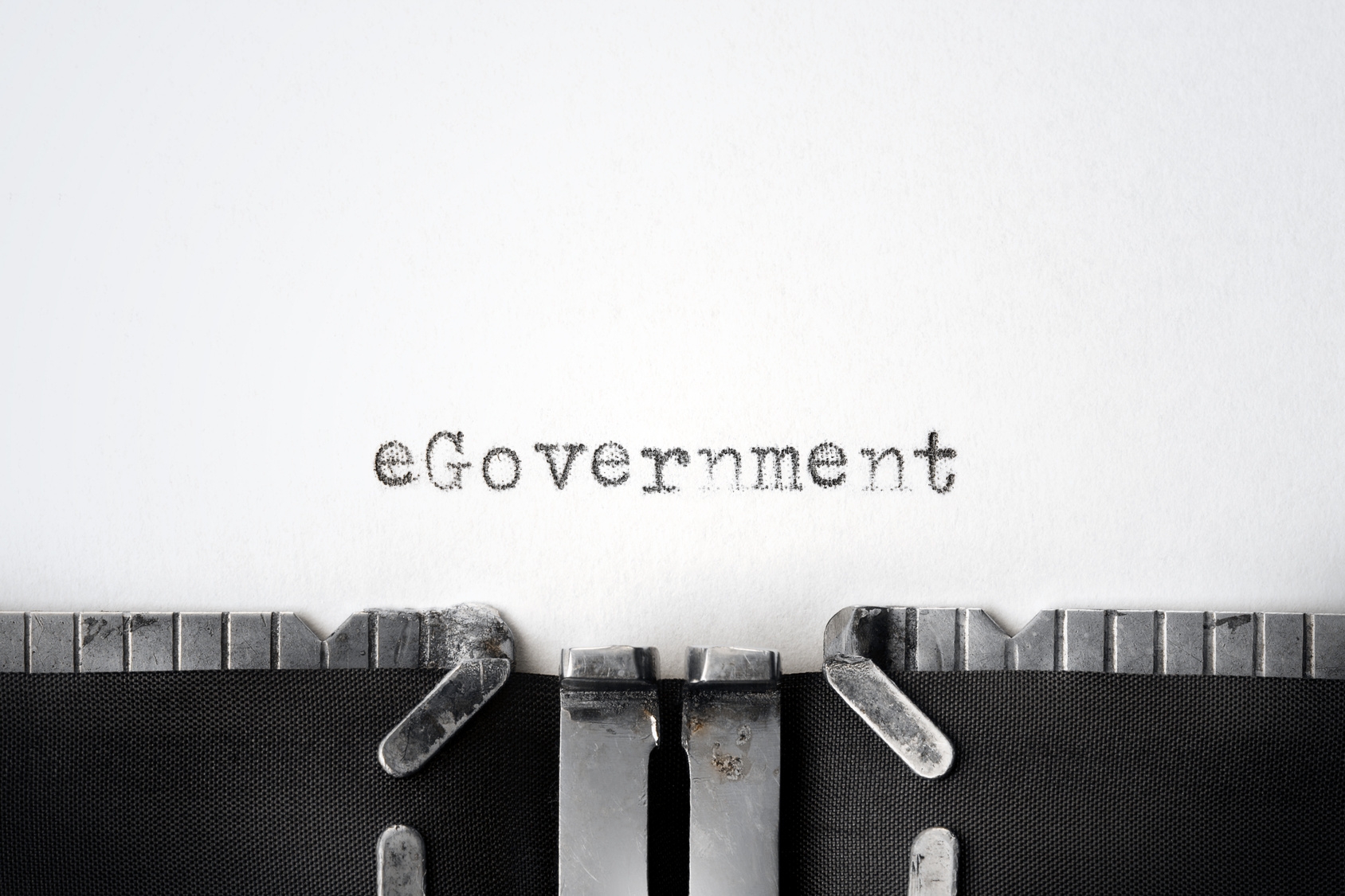 In einer Schreibmaschine befindet sich ein weiés Blatt auf welches das Wort "eGovernment" geschrieben worden ist.