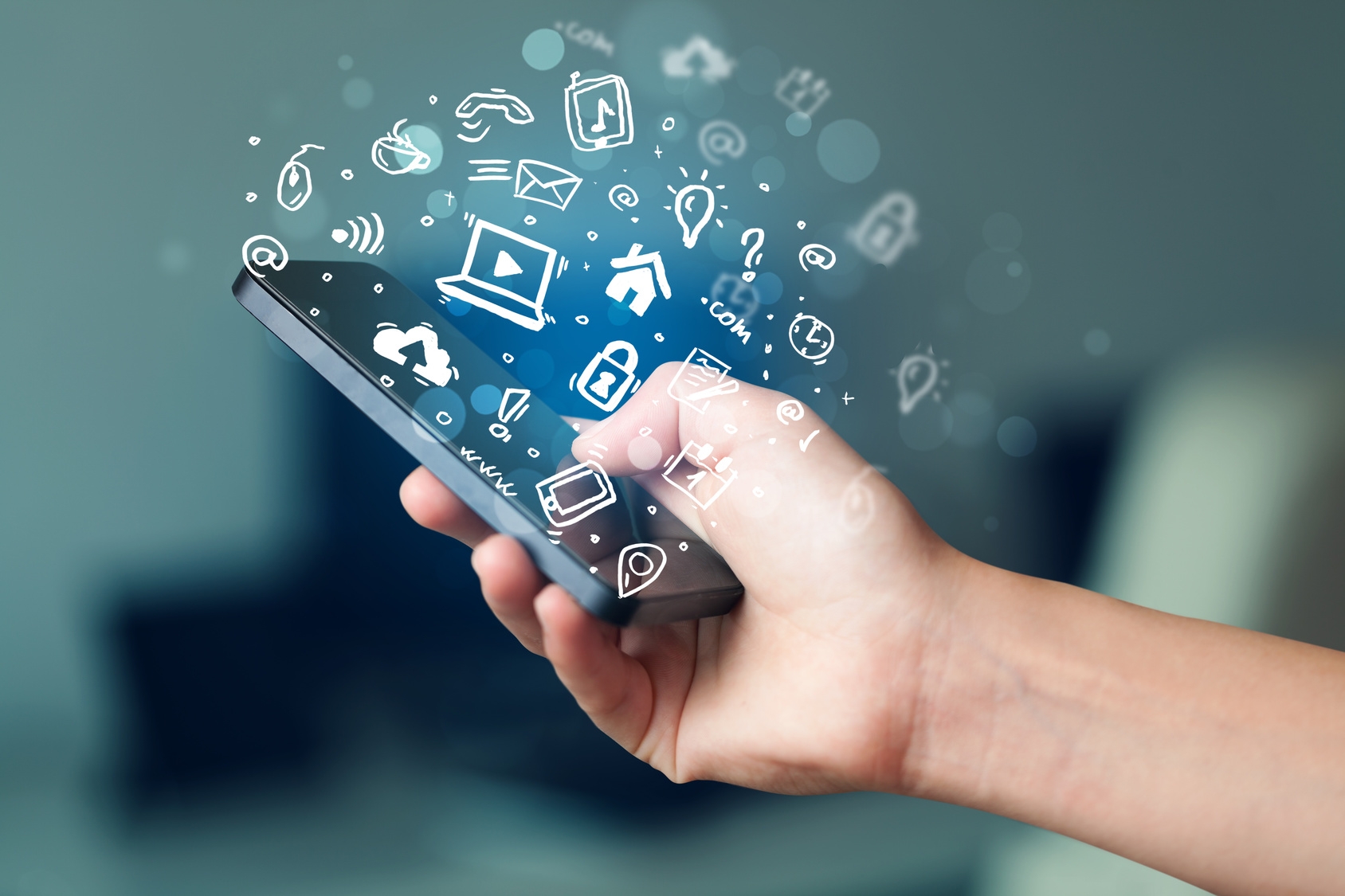 In einer Hand liegt ein Smartphone aus welchem zahlreiche Symbole ausstrahlen. Darunter sind Symbole wie SMS, Telefon oder Mail. In einer Hand liegt ein Smartphone aus welchem zahlreiche Symbole ausstrahlen. Darunter sind Symbole wie SMS, Telefon oder Mail.