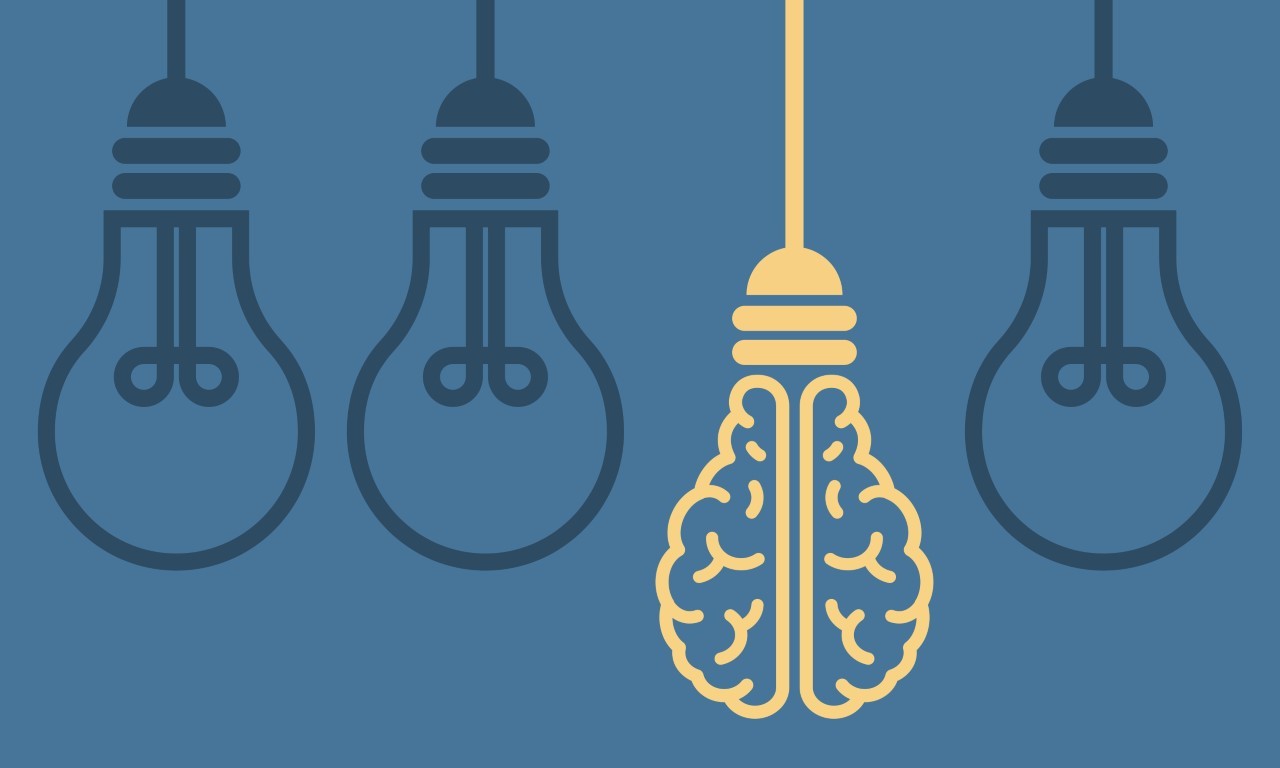 Vier Glühbirnen hängen an einer Schnur. Eine davon hat die Struktur eines Gehirns. 