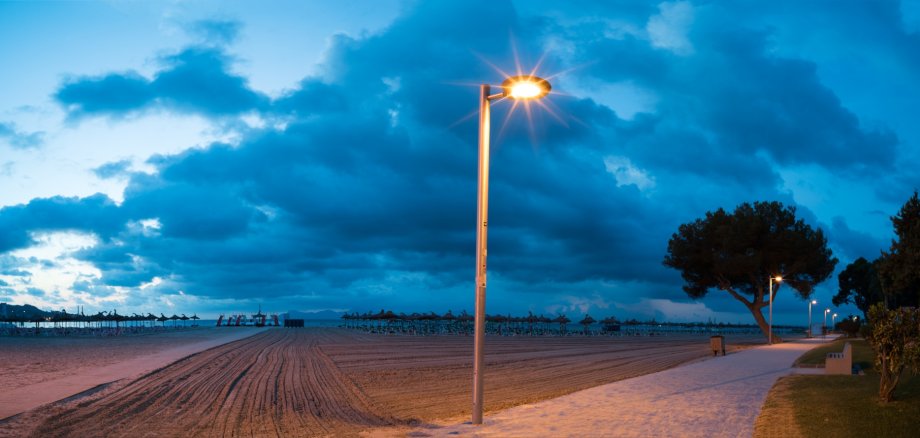 Eine leuchtende Straßenlaterne in der Nacht. 