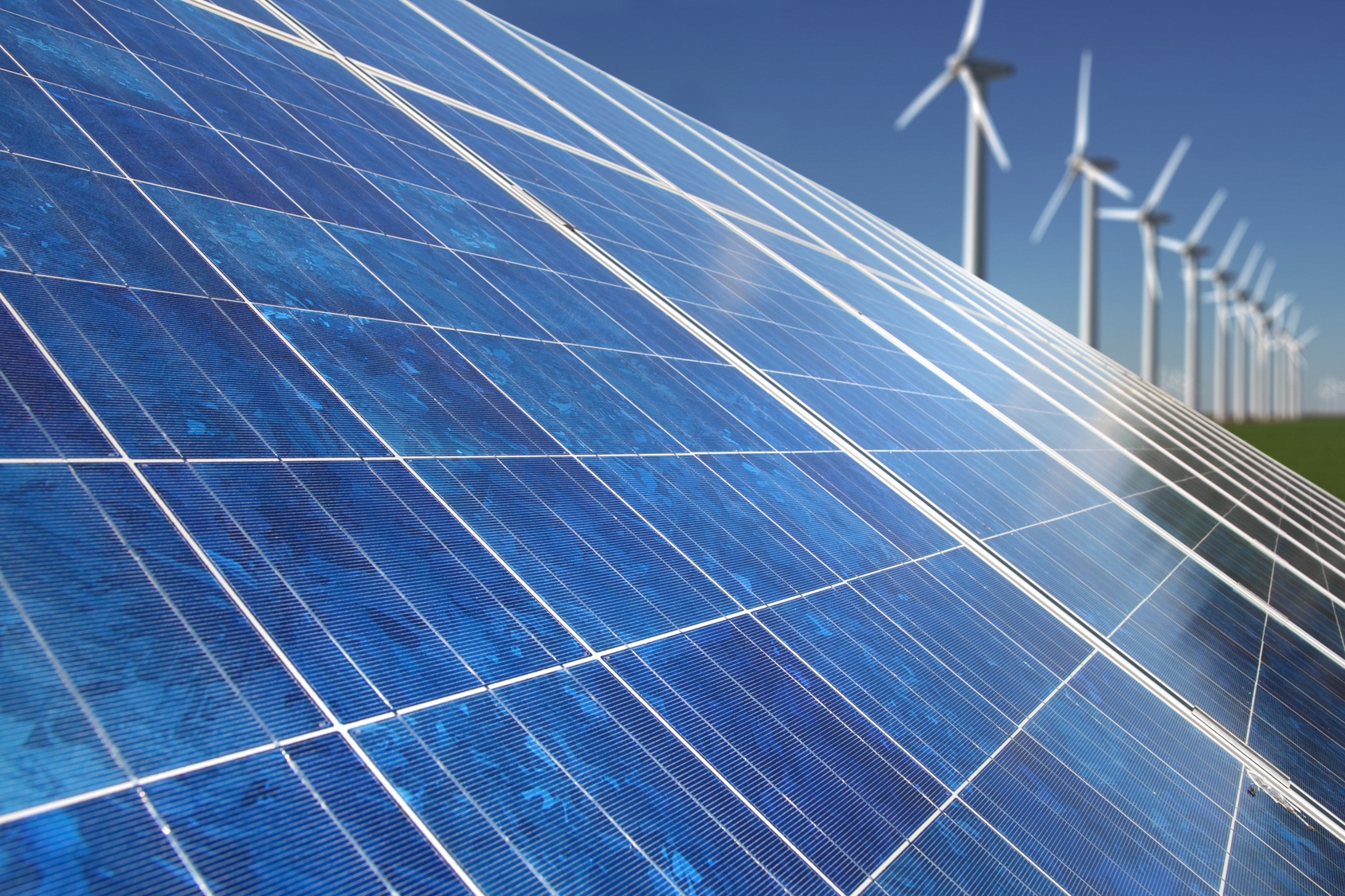 Solarpanels und im Hintergrund sind Windräder zu erkennen