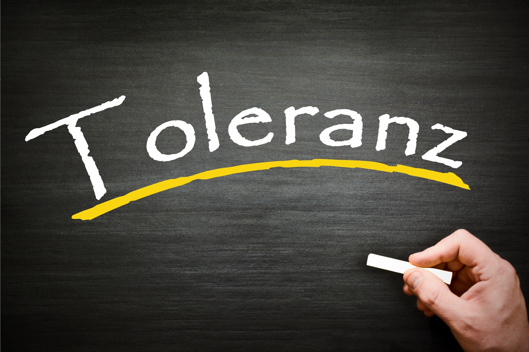Auf einer Schieferntafel steht mit Kreide das Wort Toleranz geschrieben