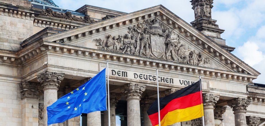 Deutscher Bundestag mit der Flagge von Deutschland und der Europa-Flagge vor dem Eingang gehisst 