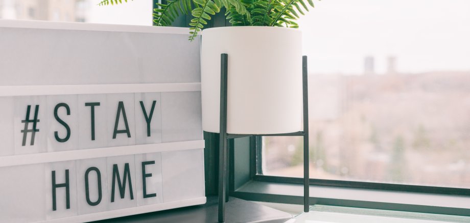Eine Lichtbox mit den Worten "Stay Home" in einem Raum.