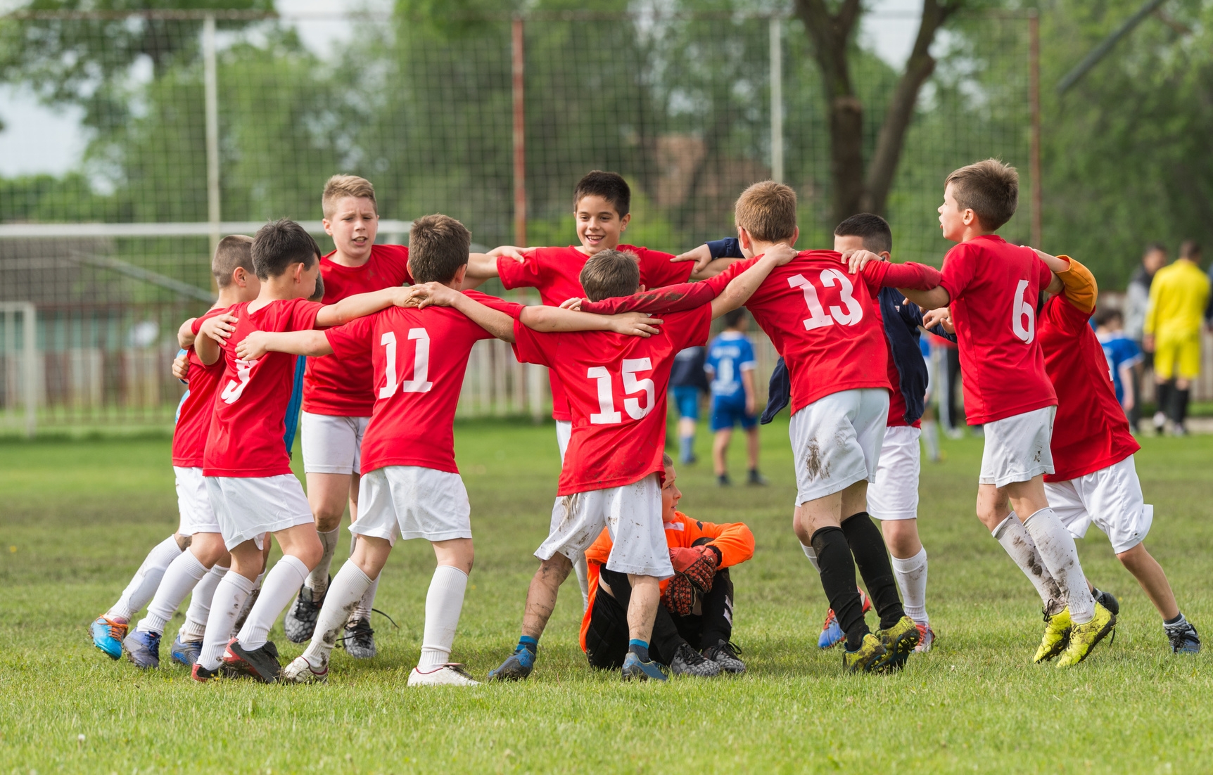 Fußballteam im Kreis auf dem Feld.