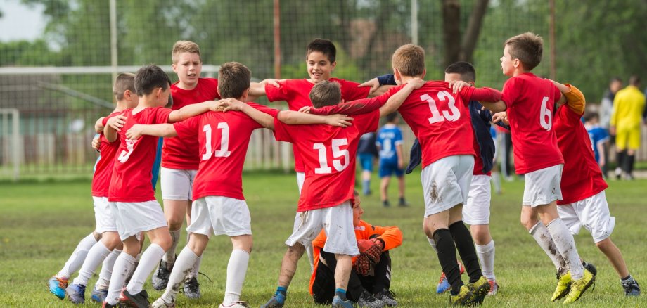 Fußballteam im Kreis auf dem Feld.