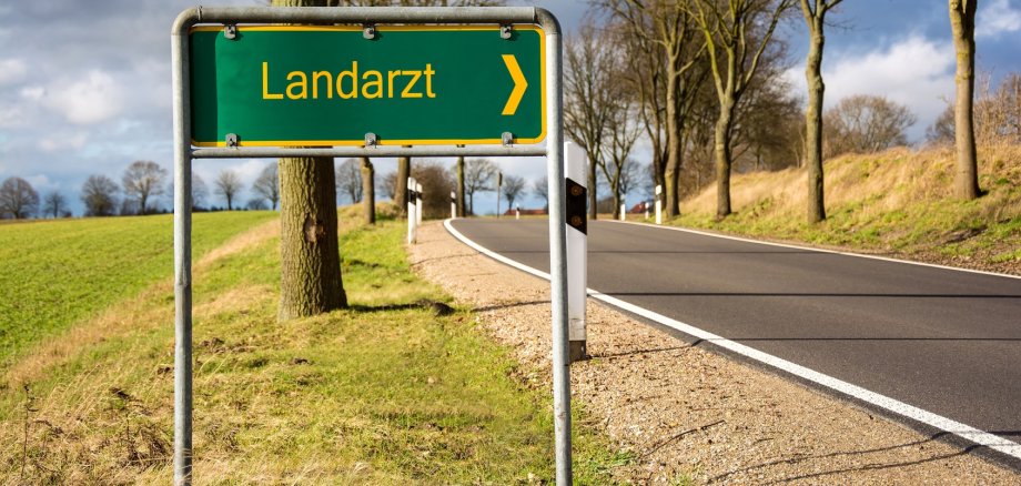 Straße mit Schild, das "Landarzt" anzeigt.