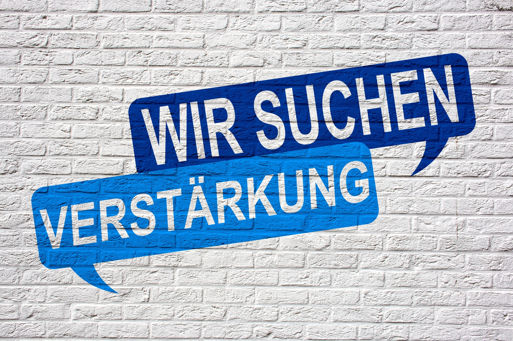 Aufschrift auf Mauer "Wir suchen Verstärkung".