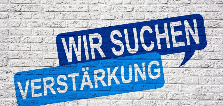 Aufschrift auf Mauer "Wir suchen Verstärkung".