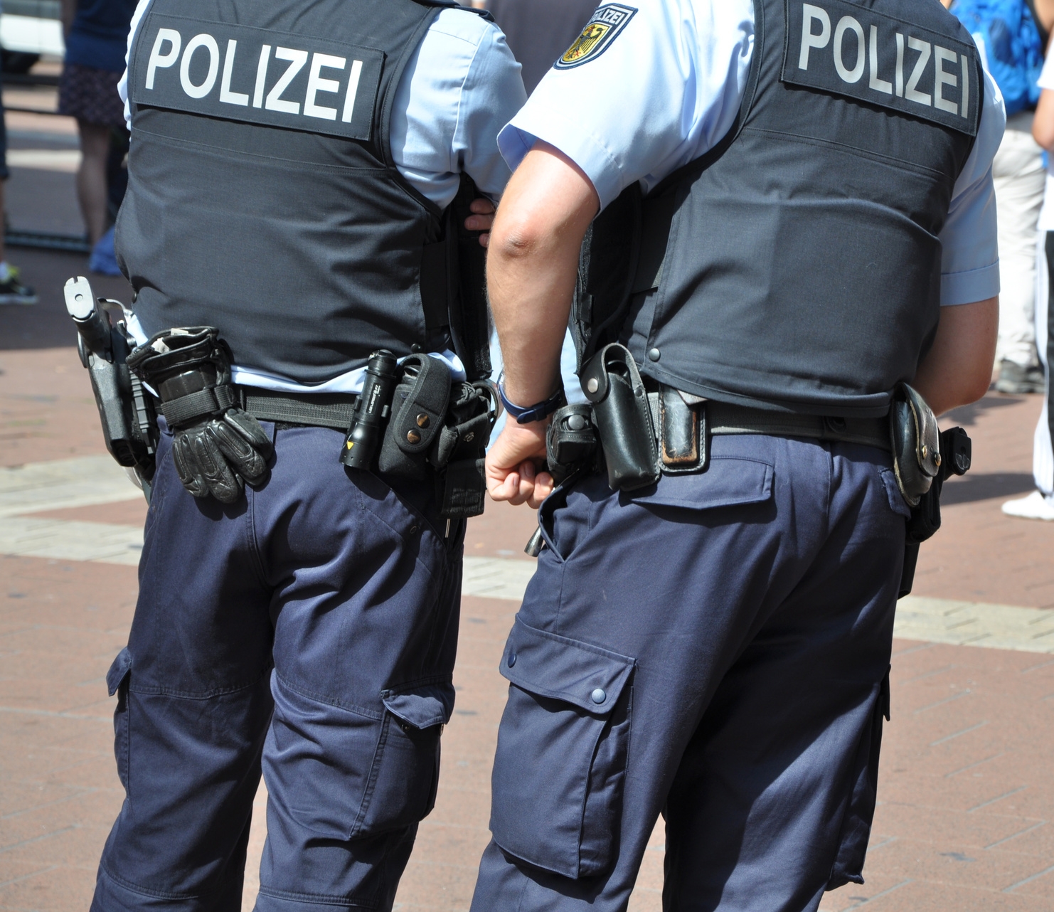 Zwei Polizisten in Uniform und mit Waffen nebeneinander. Zwei Polizisten in Uniform und mit Waffen nebeneinander.