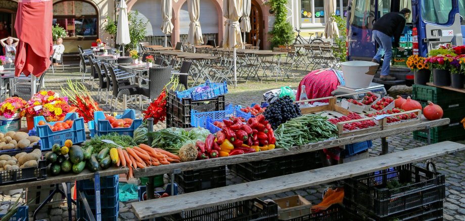 Blumen-, Frucht- und Gemüsestände eines Marktes.