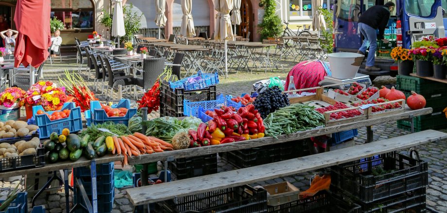 Blumen-, Frucht- und Gemüsestände eines Marktes.