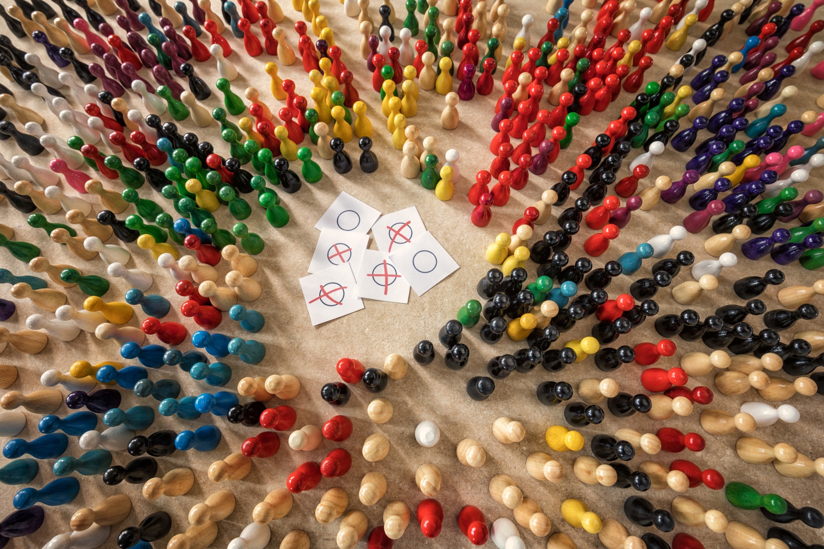 Viele Spielfiguren, die einen Kreis um Wahlzettel bilden Viele Spielfiguren, die einen Kreis um Wahlzettel bilden