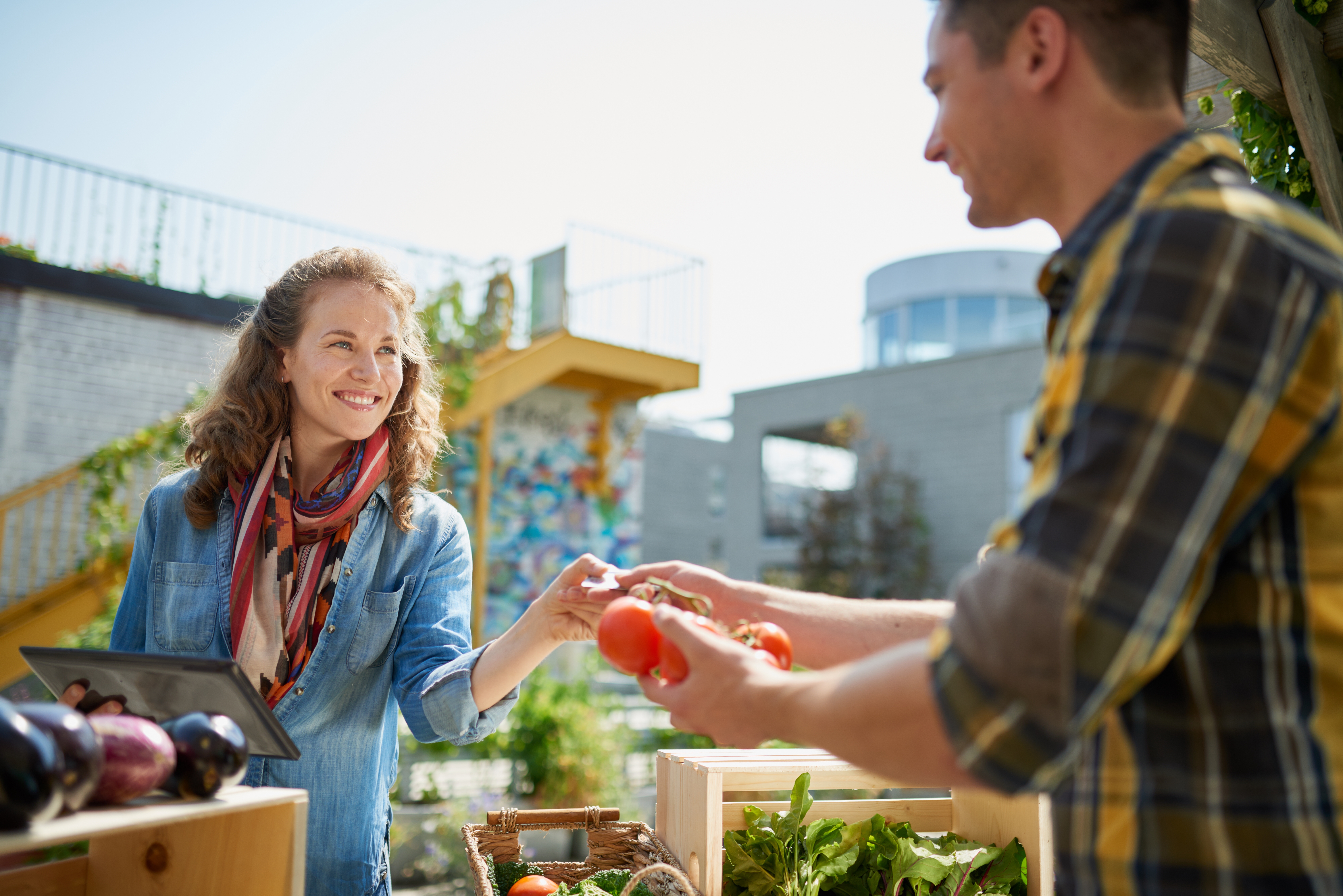 Eine Frau und ein Mann am Obst- und Gemüsestand eines Wochenmarktes Eine Frau und ein Mann am Obst- und Gemüsestand eines Wochenmarktes