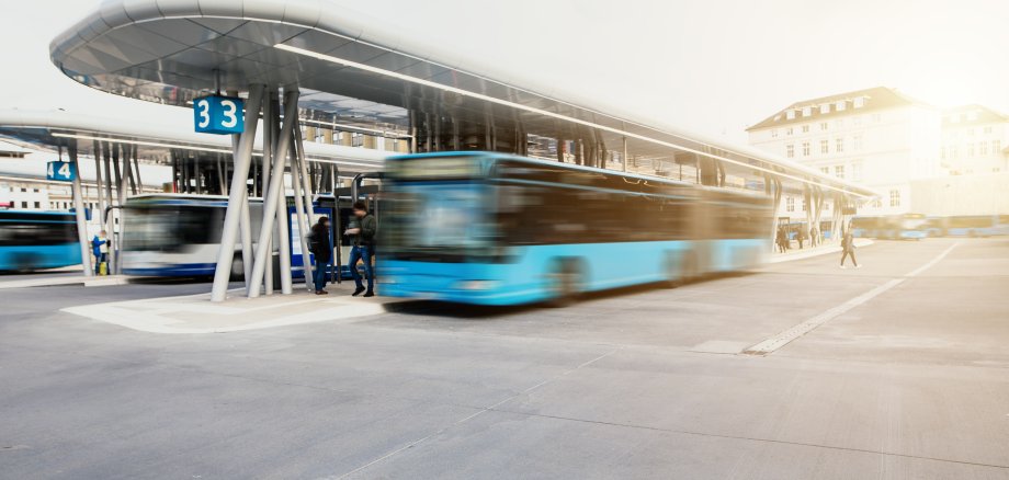 Bus fährt von der Bushaltestelle am modernen Busbahnhof los