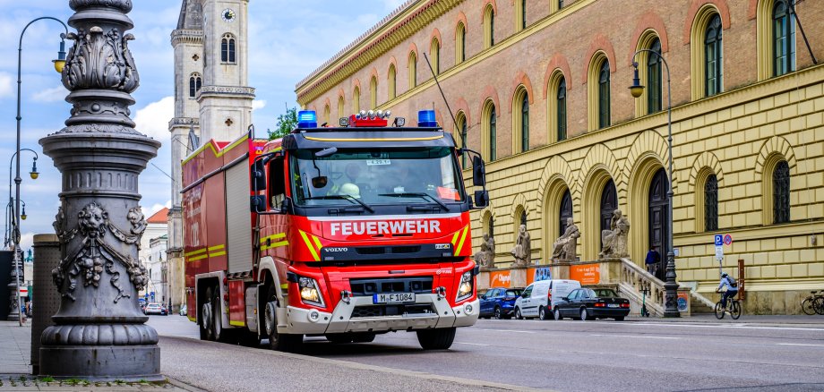 Feuerwehrauto fährt durch eine Straße in München