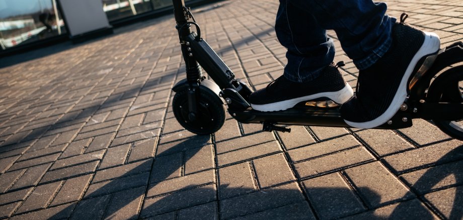 Nahaufnahme einer Person auf einem E-Scooter