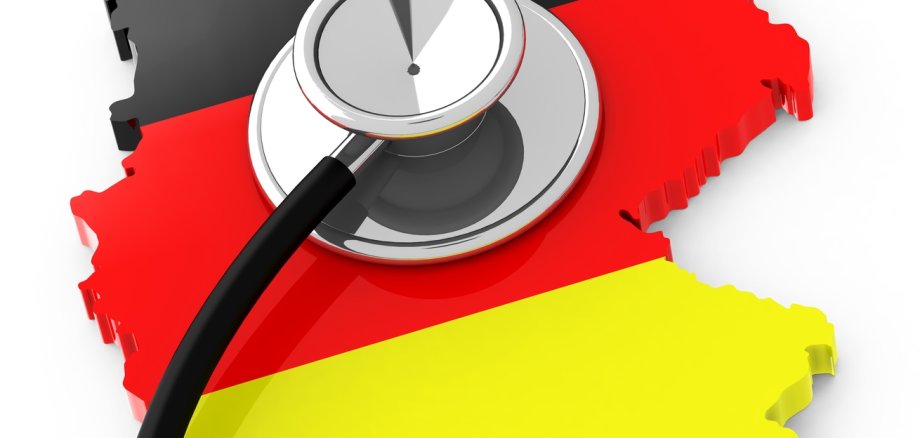 Deutschlandkarte in schwarz, rot, gelb auf der ein Stetoskop liegt.