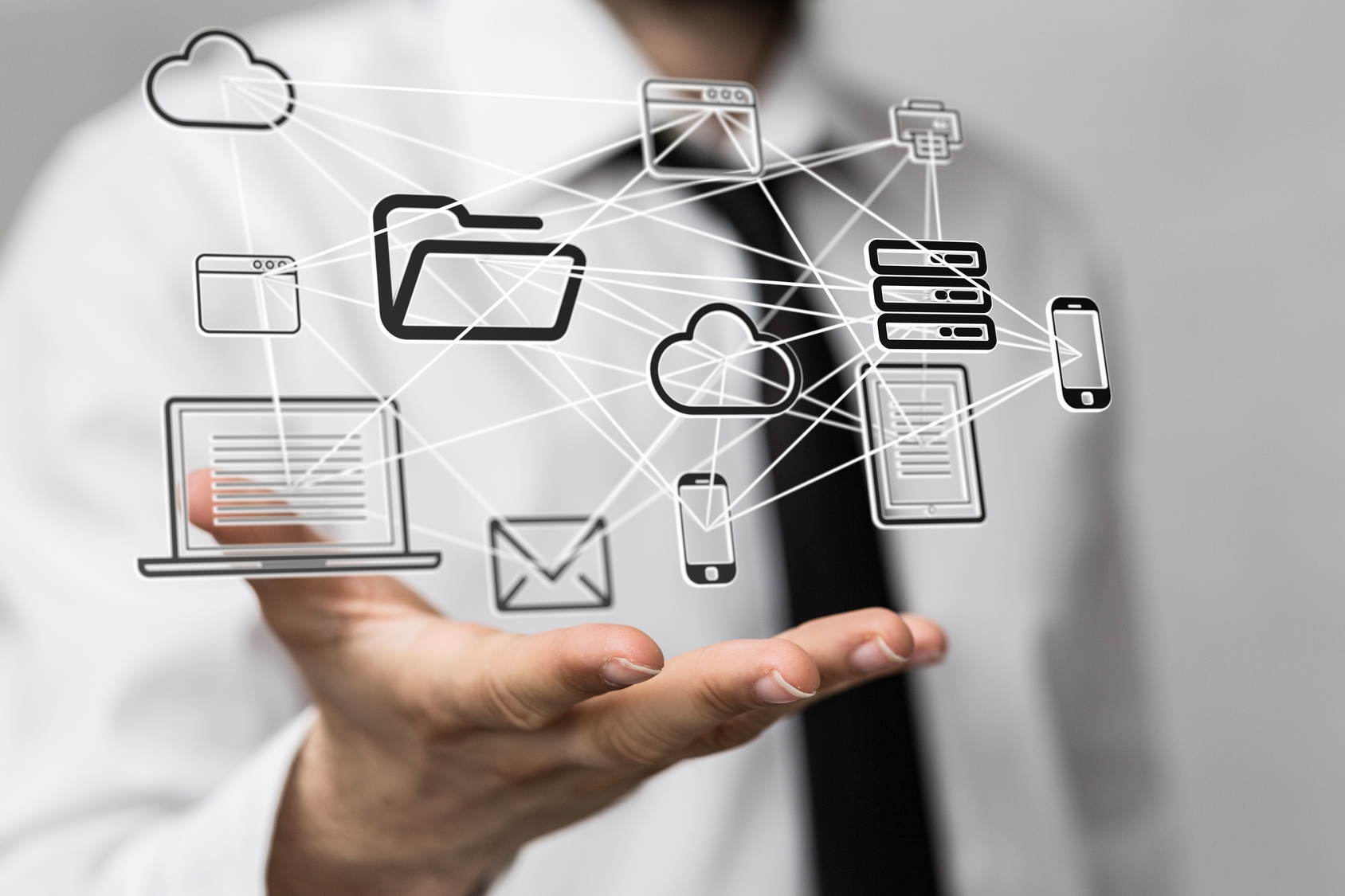 Über rechter Hand eines Mannes befindet sich vernetzte Symbolbilder von Computer, Cloud, Datenordnern usw. Über rechter Hand eines Mannes befindet sich vernetzte Symbolbilder von Computer, Cloud, Datenordnern usw.