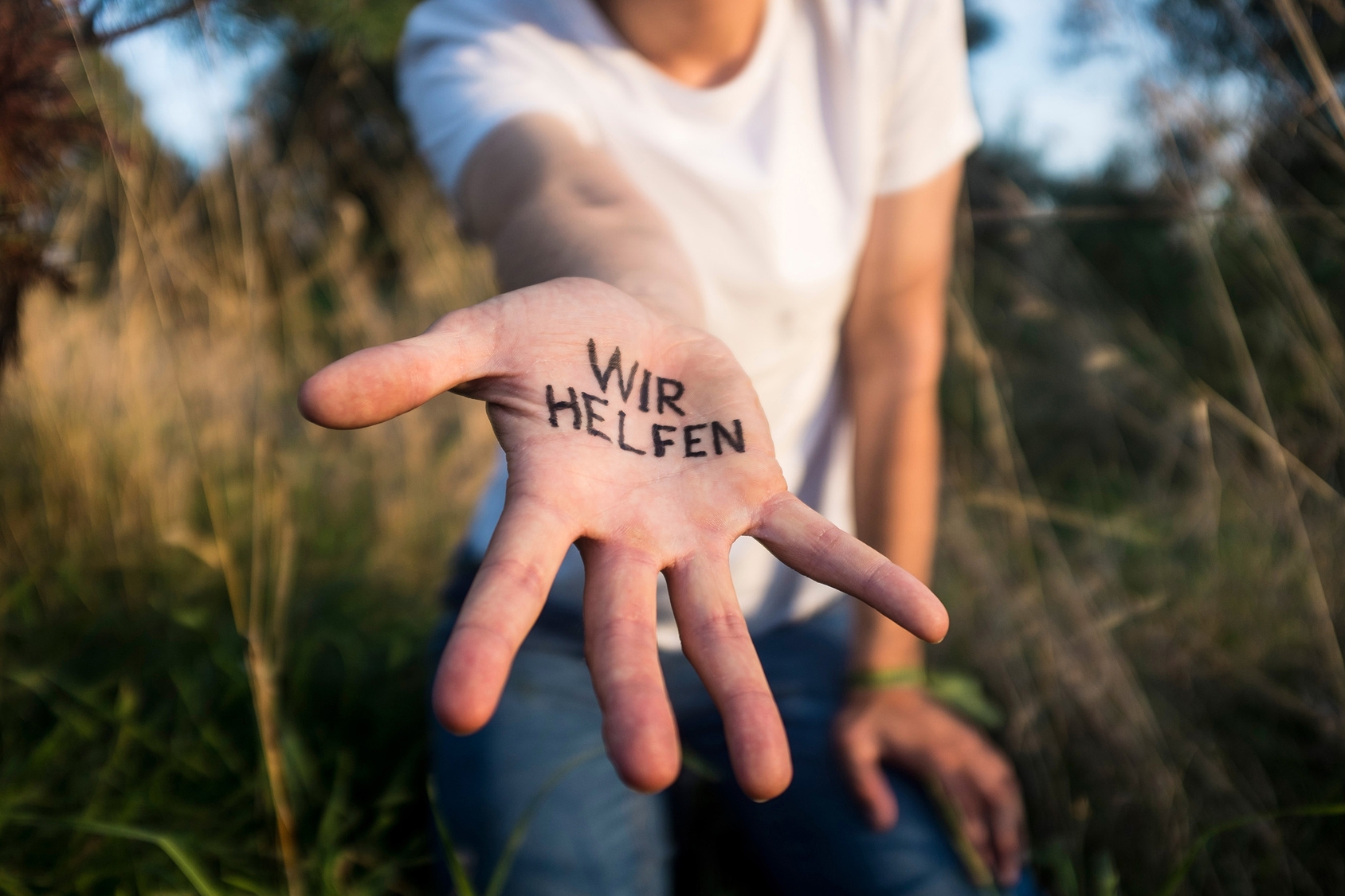Eine offene Hand mit der Aufschrift "Wir helfen!" Eine offene Hand mit der Aufschrift "Wir helfen!"