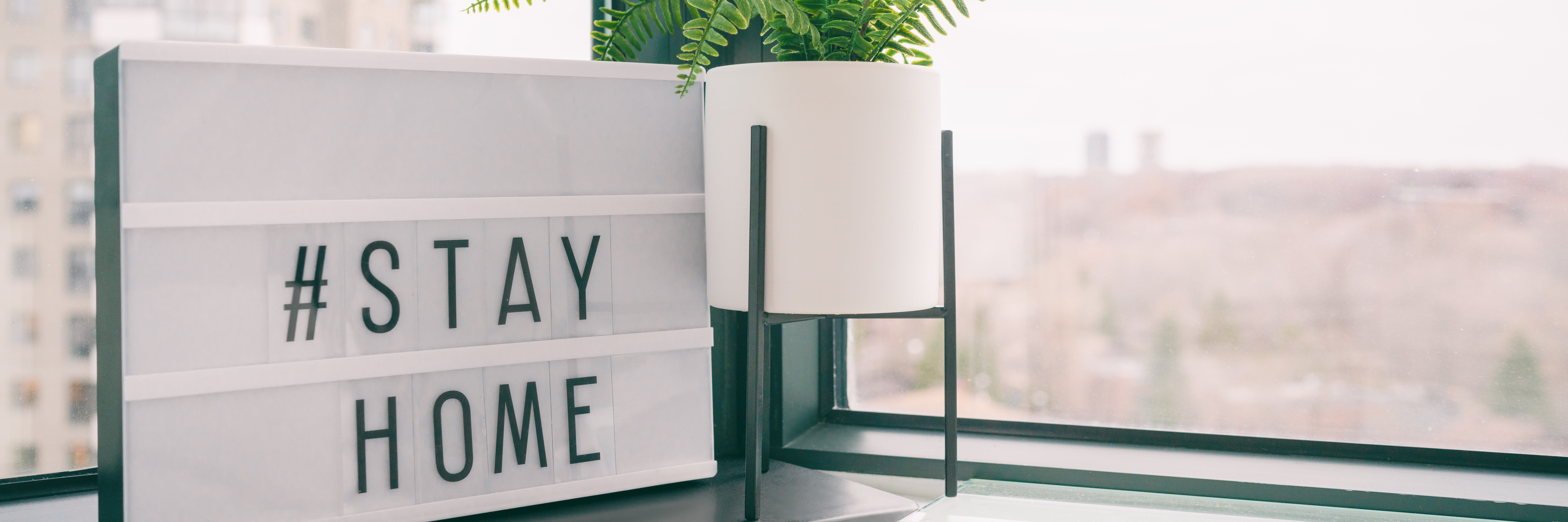 Eine Lichtbox mit den Worten "Stay Home" in einem Raum. Eine Lichtbox mit den Worten "Stay Home" in einem Raum.