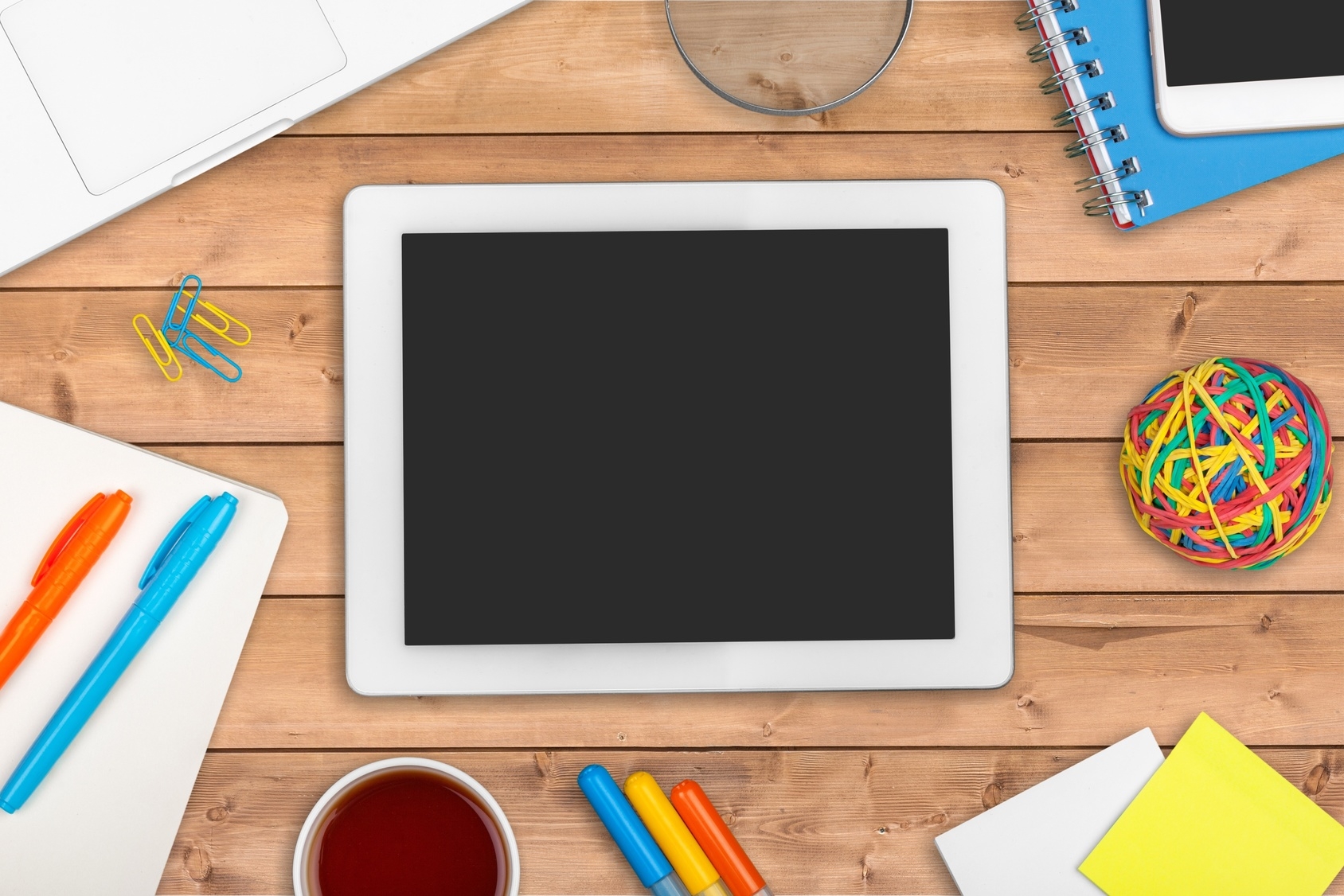 Ein Tablet auf einem Tisch mit Schreibmaterialien, digital illustriert. Ein Tablet auf einem Tisch mit Schreibmaterialien, digital illustriert.