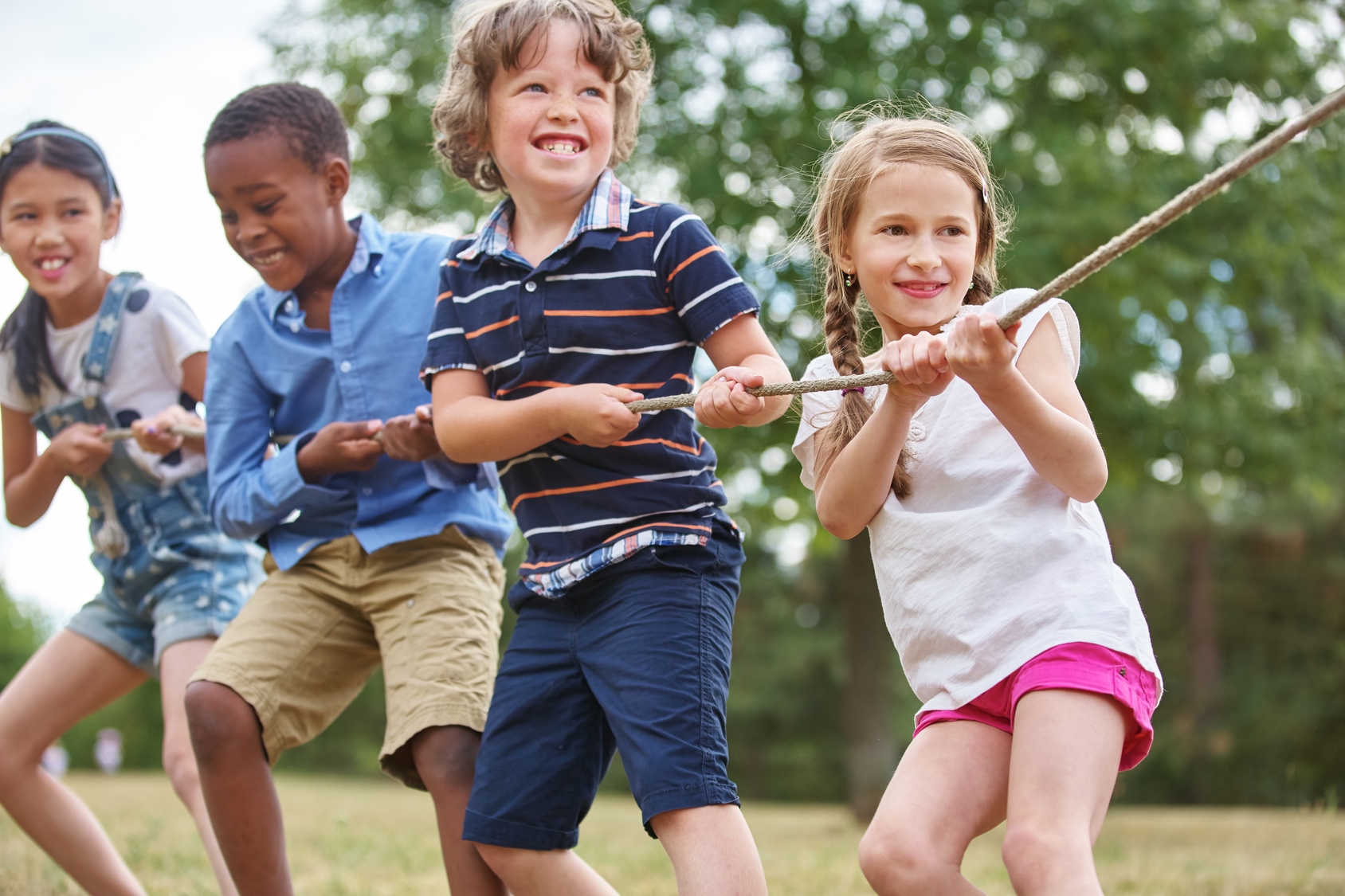 Kinder, die gemeinsam an einem Tau ziehen. Kinder, die gemeinsam an einem Tau ziehen.