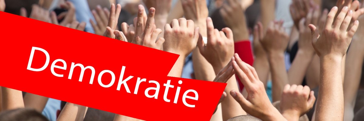 Menschen auf einem Konzert mit gehobenen Händen. Im Vordergrund ein roter Balken mit der Aufschrift "Demokratie". Menschen auf einem Konzert mit gehobenen Händen. Im Vordergrund ein roter Balken mit der Aufschrift "Demokratie".